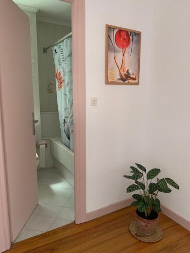a bathroom with a plant and a picture on the wall at casa loopez Hostel in Laredo