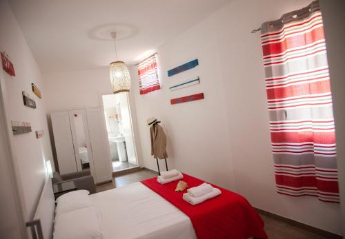 a bedroom with a white bed and a red blanket at Orlando Bayview in Balestrate