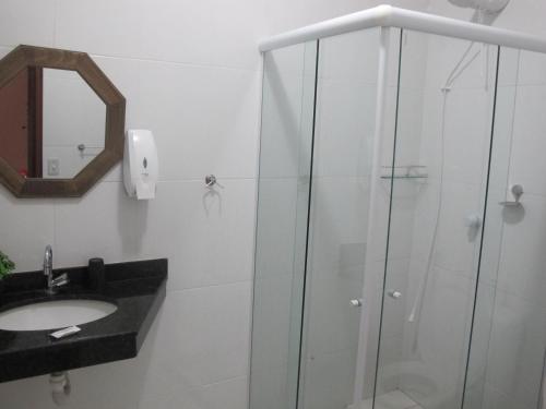 uma casa de banho com uma cabina de duche em vidro e um lavatório. em Hope Pousada em Arraial do Cabo