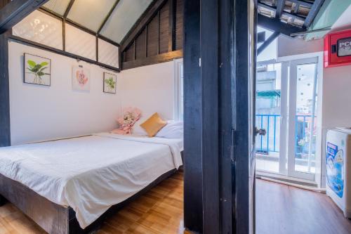 een slaapkamer met een bed en een groot raam bij Zuka Hotel & Apartment in Da Nang