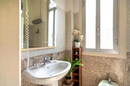 uma casa de banho com um lavatório e um espelho em La Bombetta Cheerful Apartment em Bari