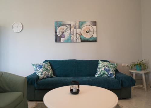a living room with a blue couch and a white table at Raptis Guest House in Tsilivi