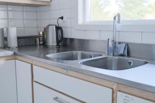 eine Küchentheke mit einem Waschbecken und einem Fenster in der Unterkunft Gullbrannagården in Halmstad