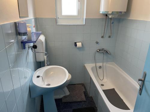 een badkamer met een wastafel, een toilet en een bad bij Apartment Tulip in Premantura