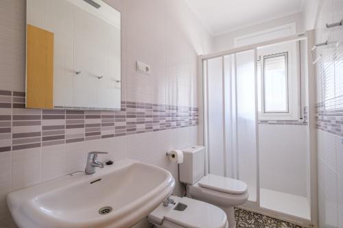 une salle de bain blanche avec un lavabo et des toilettes dans l'établissement Can Quetu, à Vinaròs