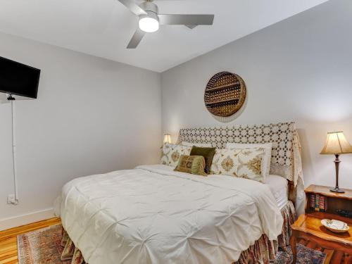 a white bedroom with a bed and a television at Above Broughton St 3002 in Savannah
