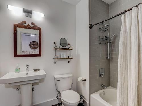 a bathroom with a white toilet and a sink and a shower at Above Broughton St 3002 in Savannah