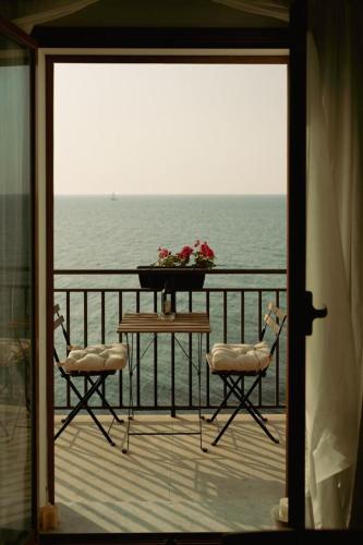 a balcony with a table and two chairs and the ocean at Terrazza Roberto in Cefalù