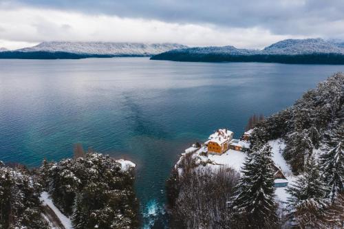 an aerial view of a house in the middle of a lake at Correntoso Lake & River Hotel in Villa La Angostura