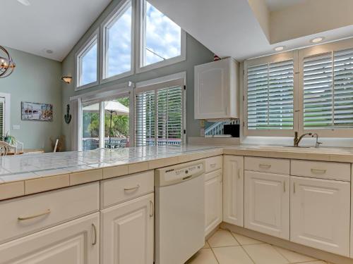 een grote keuken met witte kasten en ramen bij Salty Shores in Tybee Island