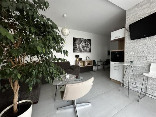 a living room with a couch and a table with a plant at Apartmán Lodenica in Piešťany
