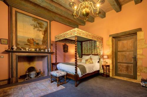 ein Schlafzimmer mit einem Himmelbett und einem Kamin in der Unterkunft Logement d'exception dans le Château de Lacypierre in Saint-Crépin-et-Carlucet