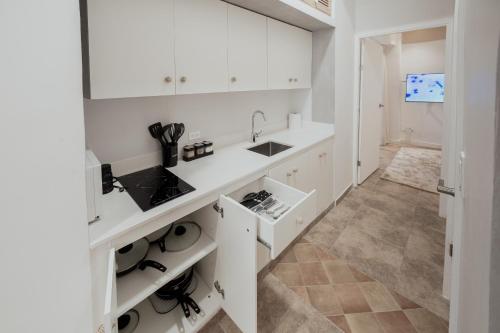 a kitchen with white cabinets and a sink at AmazINN Places Casco Viejo Jacuzzi, Adults only in Panama City