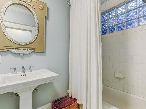 La salle de bains blanche est pourvue d'un lavabo et d'un miroir. dans l'établissement Victoria's on Lincoln, à Savannah