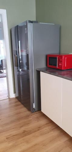 a kitchen with a refrigerator with a microwave on a counter at Centrum lägenhet in Skövde