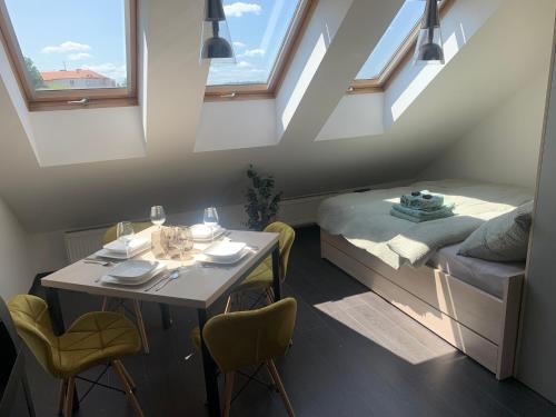 a room with a table and a bed and windows at Relax & Active Apartment Tábor in Tábor
