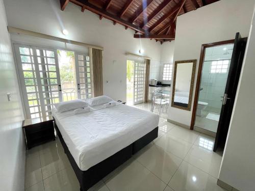 a bedroom with a large bed and a bathroom at Nav Park Hotel in Naviraí