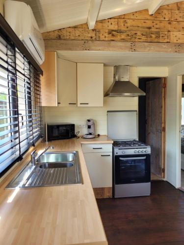 een keuken met een wastafel en een fornuis bij Rustig gelegen chalet Solvo met terras aan het water in Geel
