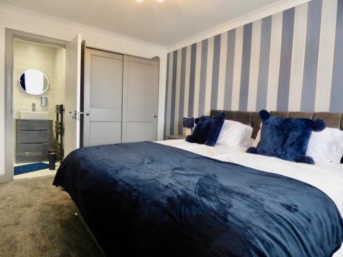 a bedroom with a large bed with blue pillows at Millies Holiday Home in Blackpool