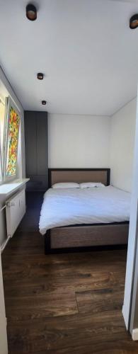 una camera con un grande letto e pavimenti in legno di Jaukus 2 kambarių butas Mažeikiuose a Mažeikiai