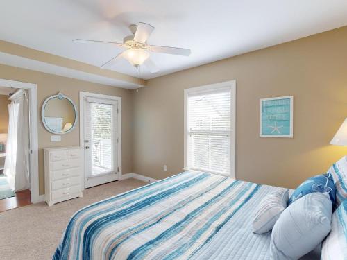een slaapkamer met een bed en een plafondventilator bij Silver Shores Unit 8 in Tybee Island