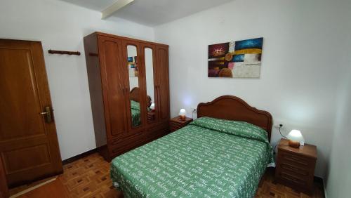 1 dormitorio con 1 cama con edredón verde en Rúa Panadeira 3 1º, en Sanxenxo