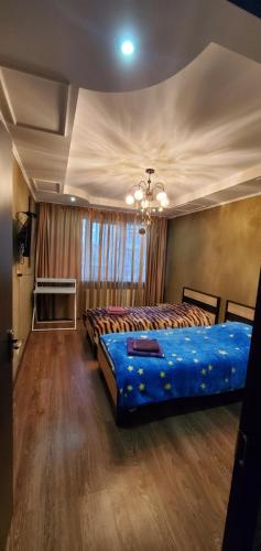 a bedroom with two beds and a chandelier at Апартаменти біля дельфінарію in Truskavets