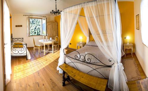 a bedroom with a canopy bed and a dining room at Il Poggio di Maro' in Badalucco