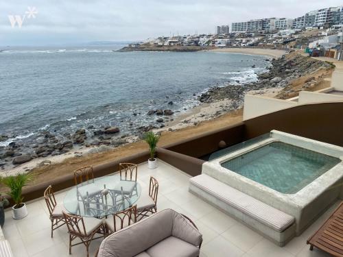 balcone con tavolo, sedie e vista sull'oceano di Stunning House in Front Row with Pool in PH a Lima