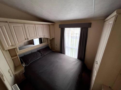 a small bedroom with a bed and a window at Heron View Holiday Home in Balminnoch