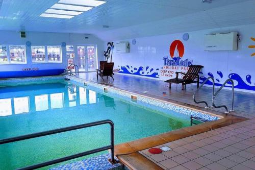 a large swimming pool in a hotel room at Heron View Holiday Home in Balminnoch