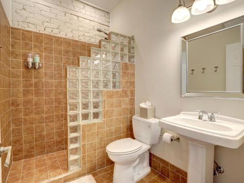 La salle de bains est pourvue de toilettes, d'un lavabo et d'un miroir. dans l'établissement Broughton Retreat, à Savannah