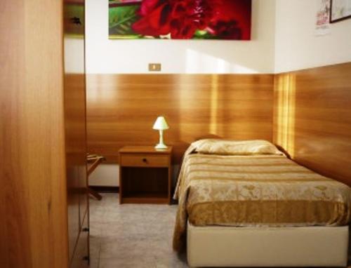 1 dormitorio con 1 cama y 1 mesa con lámpara en Hotel Sport, en Portogruaro