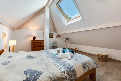 Schlafzimmer mit einem großen Bett und einem Dachfenster in der Unterkunft Coquet T2. Exceptionnel entre lac et montagnes in Menthon-Saint-Bernard