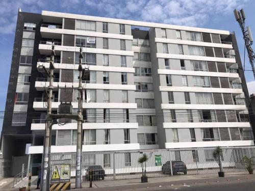 un gran edificio de apartamentos blanco en una calle de la ciudad en Lindo Departamento en Av. Guardia Civil 861 - Chorrillos, en Lima