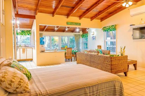 a bedroom with a large bed and a kitchen at Breeze by the sea in Five Islands Village