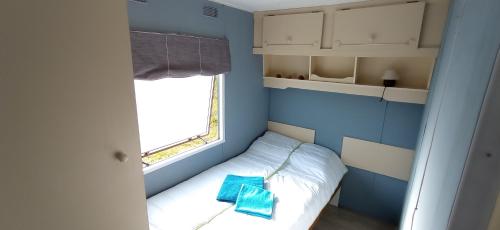 Cette petite chambre comprend un lit et une fenêtre. dans l'établissement Domek nad Zalewem, à Grudki