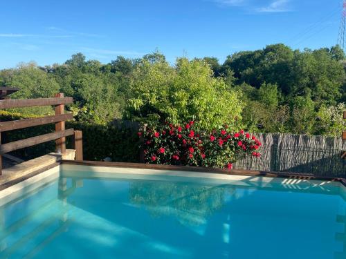 a swimming pool with a fence and flowers at Villa Paola in Villa San Leonardo