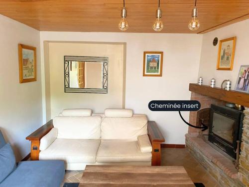 a living room with a white couch and a fireplace at Prés de Luchon, Maison Moderne in Guran