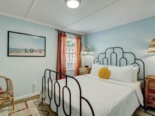 a bedroom with a white bed with a metal frame at Walking on Sunshine in Tybee Island