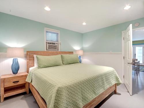 um quarto com uma cama com uma colcha verde em Tybee Tyme Lower em Tybee Island