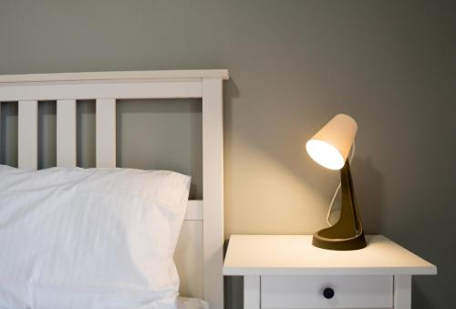 a lamp on a night stand next to a bed at Raptis Guest House in Tsilivi