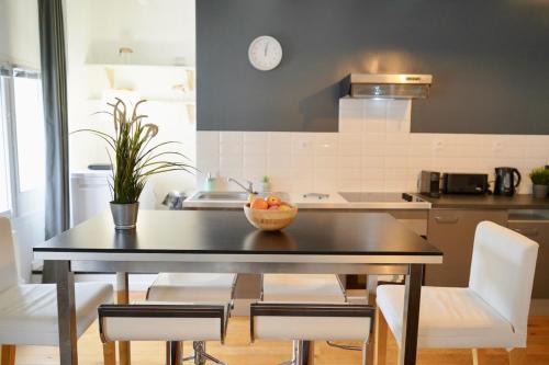 une cuisine avec une table avec un bol de fruits dessus dans l'établissement Duplex neuf 8 pers St Didier-Vaise-Lyon, à Saint-Didier-au-Mont-dʼOr