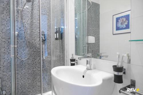 a white bathroom with a sink and a shower at Viale Giulio Cesare Guest House in Rome