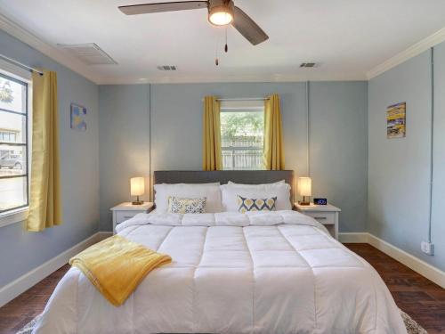 een slaapkamer met een groot wit bed en 2 ramen bij Sundial Inn Unit 2 in Tybee Island
