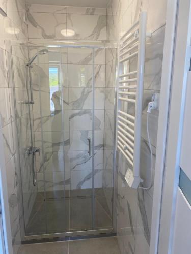 a shower with a glass door in a bathroom at Mega widok 5 in Szklarska Poręba