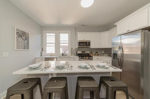 a kitchen with a large island with stools and a refrigerator at Urban Oasis in beautiful East Rock Free Parking Yale adjasent in New Haven