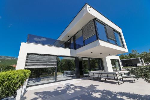 a modern house with glass doors and a roof at Luxury Villa Cloer, Jadranovo - Sauna,Steam room, 2 Jacuzzis in Jadranovo