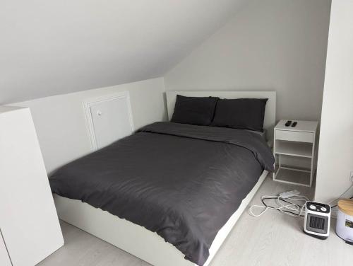 a white bedroom with a bed and a night stand at New House, Private Rooms in a Peaceful Neighborhood in Dublin