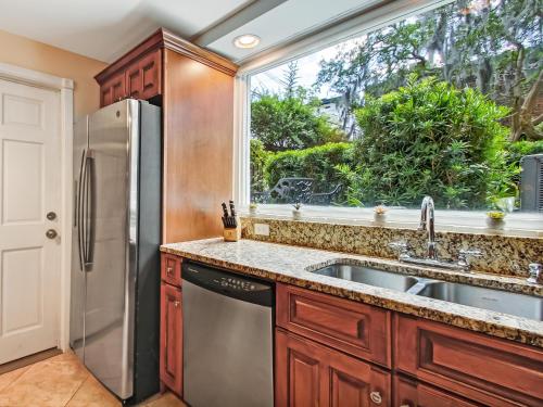 een keuken met een roestvrijstalen koelkast en een raam bij Gordon Gem in Savannah